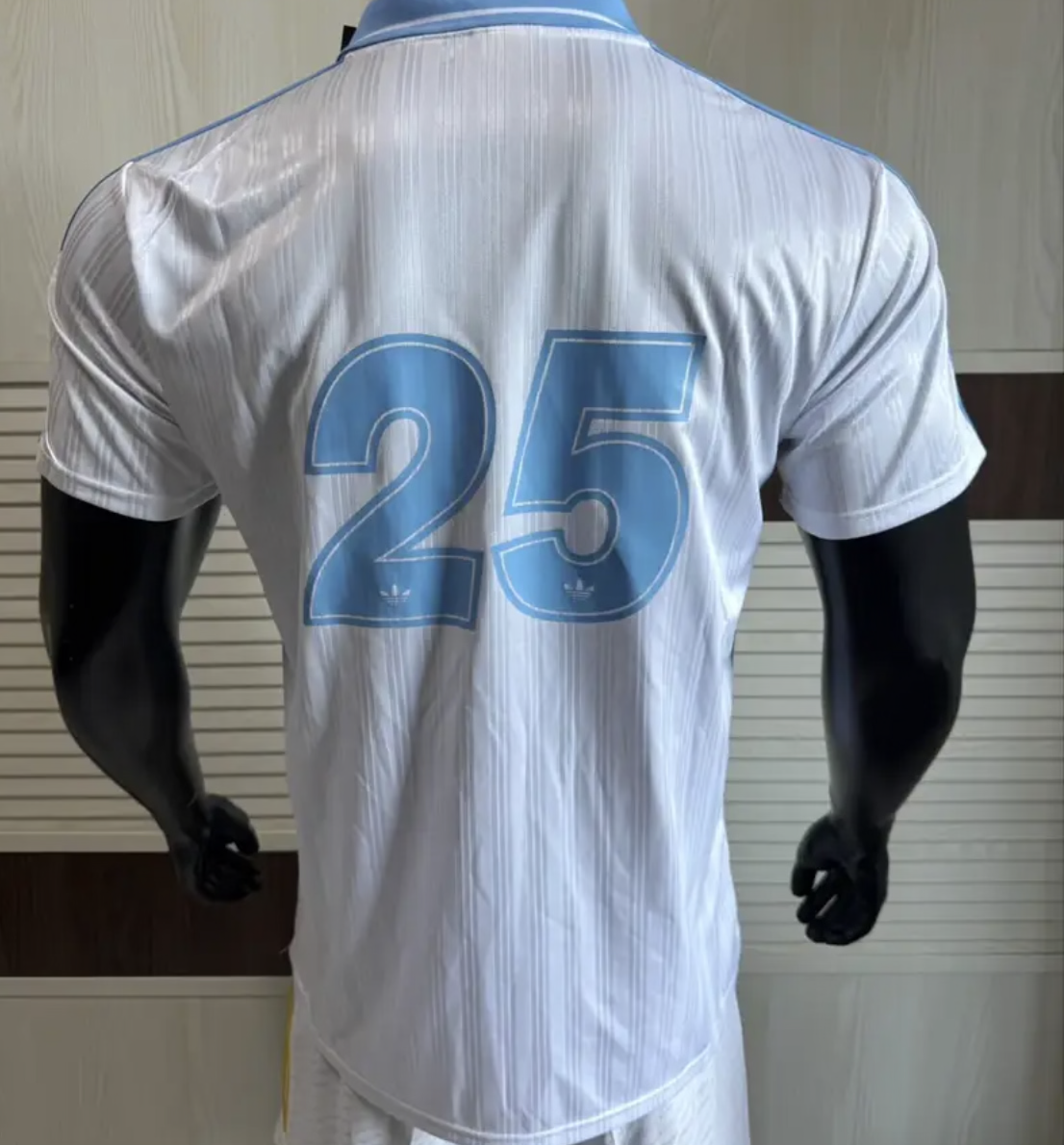 Adidas Oasis Tour “Bolt Makers Arms” edition white and sky blue short sleeve soccer jersey, featuring bold design details.