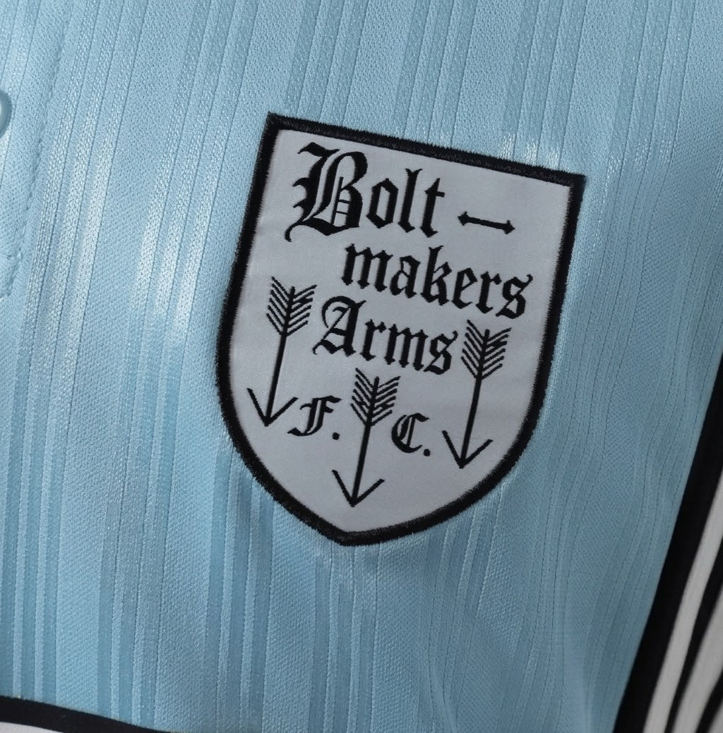 Adidas Oasis Tour “Bolt Makers Arms” blue and black short sleeve soccer jersey with team logo and Adidas branding.