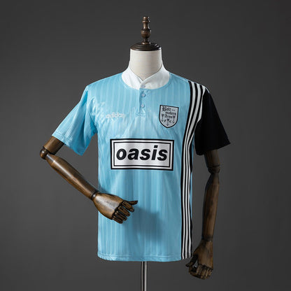 Blue and black Adidas Oasis Tour "Bolt Makers Arms" edition short sleeve soccer jersey with bold design and team logo.