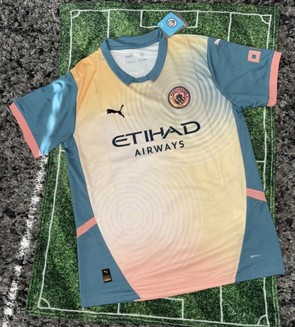 Manchester City FC 24/25 fourth jersey, short sleeve, album special edition, in blue with club crest and sponsor logos.