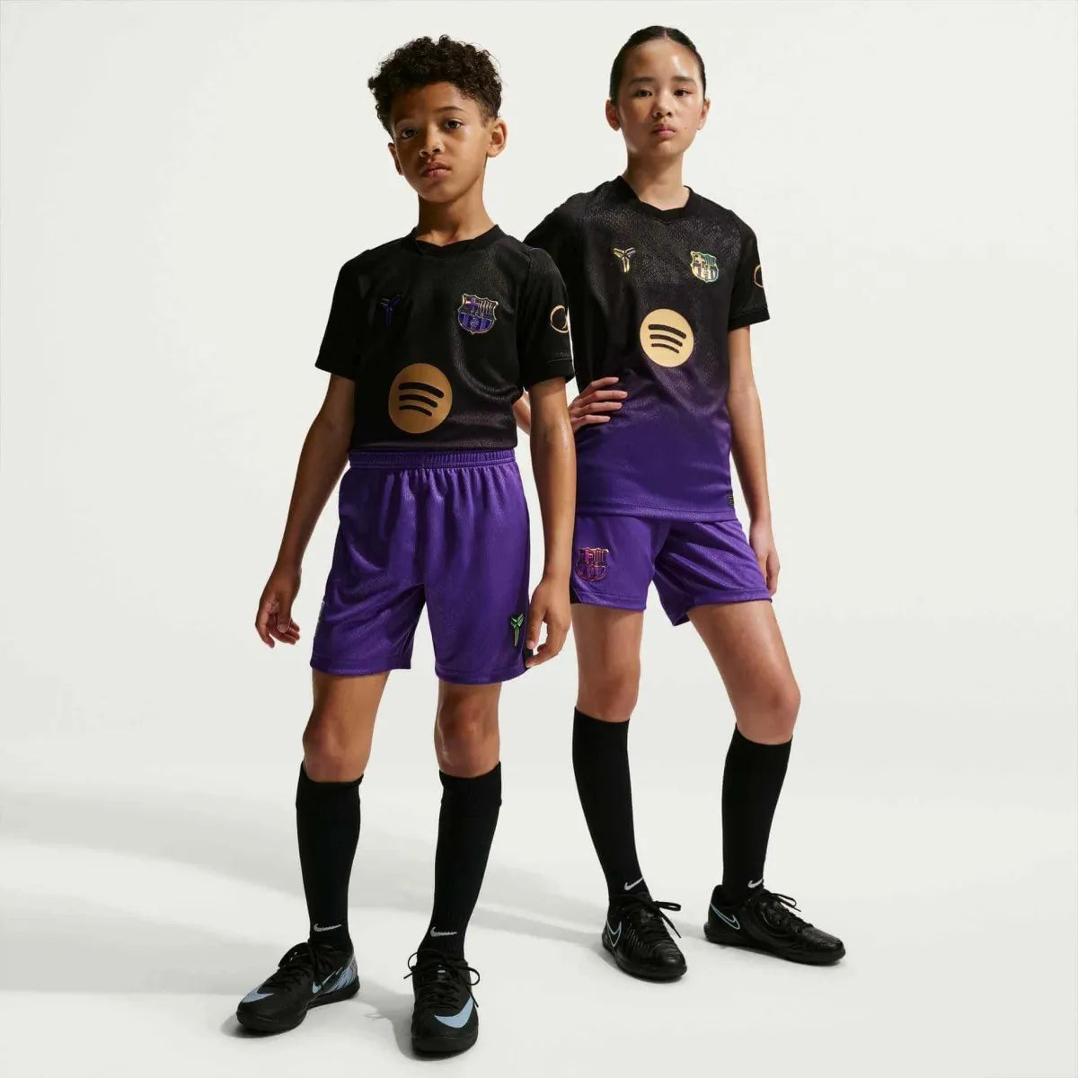Barcelona kids away soccer kit set, short sleeve home jersey, shorts, and socks, featuring team colors and logo.