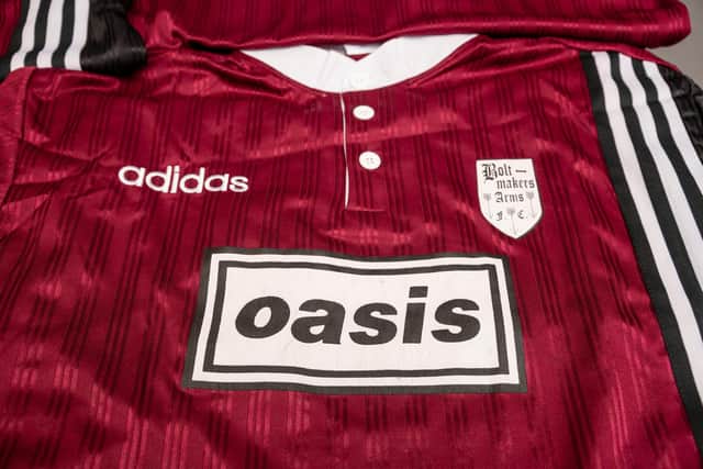 Red and black Adidas Oasis Tour short sleeve soccer jersey with "Bolt Makers Arms" edition, featuring bold design and team branding.